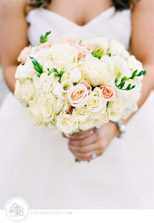 Wedding bouquet with white and pink roses being held by the bride.